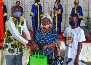 Un des anciens de l'église Alliance chrétienne d'Avéa 2, Jonas Batombi remettant un des kits scolaires à une famille