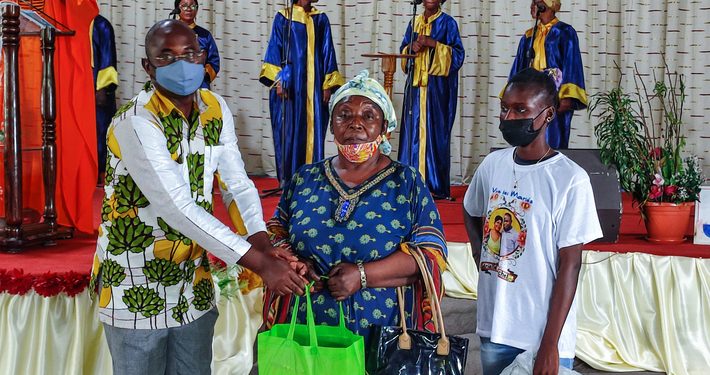 Un des anciens de l'église Alliance chrétienne d'Avéa 2, Jonas Batombi remettant un des kits scolaires à une famille
