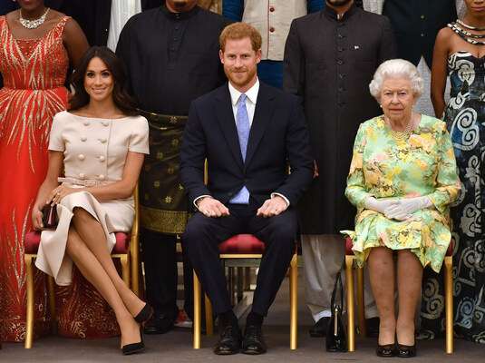 La reine Elizabeth II à droite, son petit-fils Harry au milieu et son épouse Meghan Markle 
