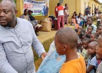 L'honorable Christian Ebe Atomo, l'émissaire du président Ali Bongo Ondimba remettant un kit scolaire à un enfant de Medouneu
