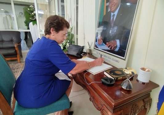 La Chargé d'Affaires, a.i. Ellen B. Thorburn des États-Unis signant le livre des condoléances en hommage au ministre Michaël Moussa Adamo de la part du monde diplomatique