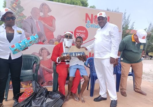 Haris Ayo Owondo, le maire de Ndzomoe devant un enfant et le père Noël à Ndzomoe